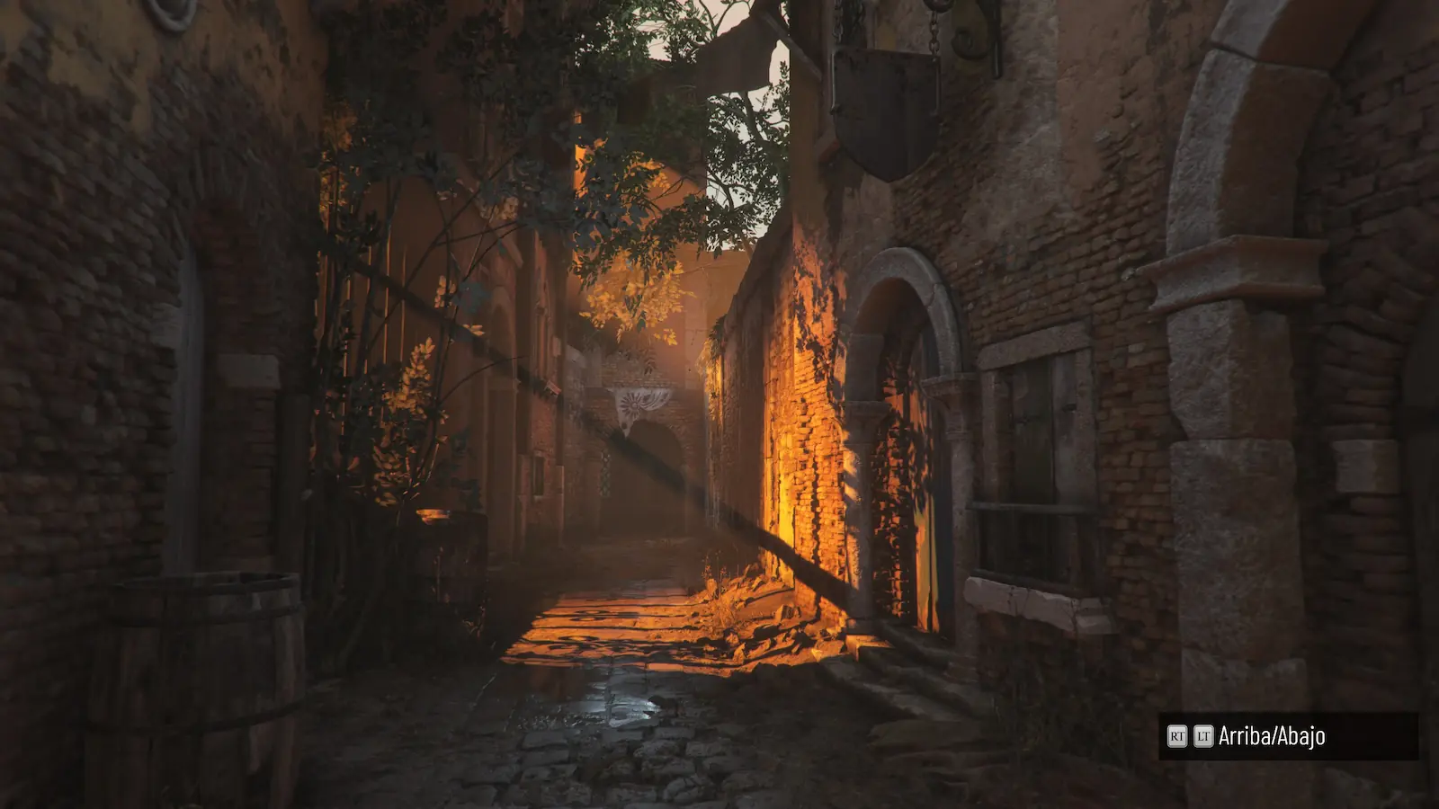 Callejón de piedra iluminado por el sol del atardecer entre muros de ladrillo