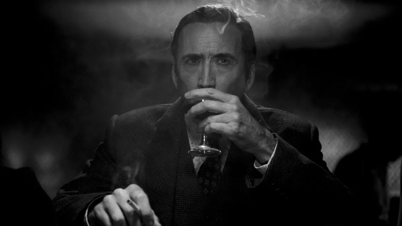 Nicolas Cage como Ben Reilly bebe de una copa con un cigarrillo encendido en la otra mano, en Spider-Noir