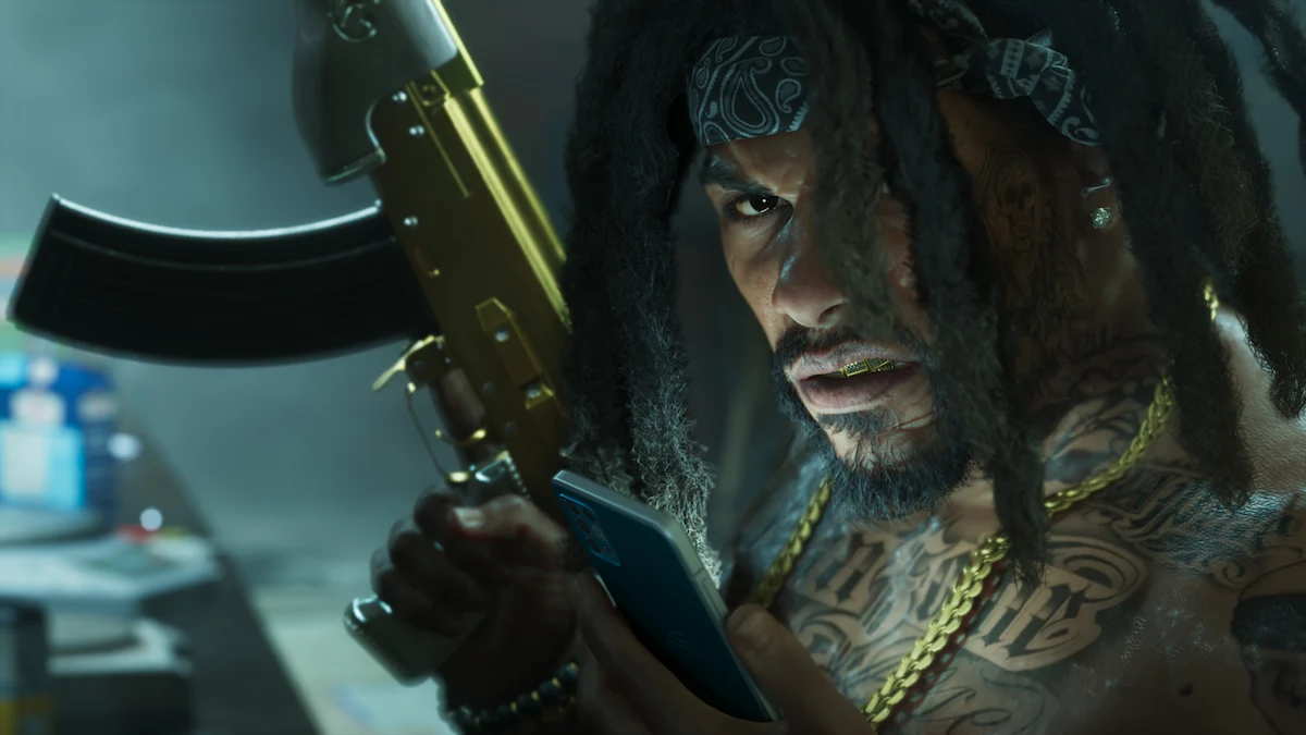 Un NPC de GTA 6 con rastas, bandana y cadenas de oro sostiene un rifle mientras mira el celular