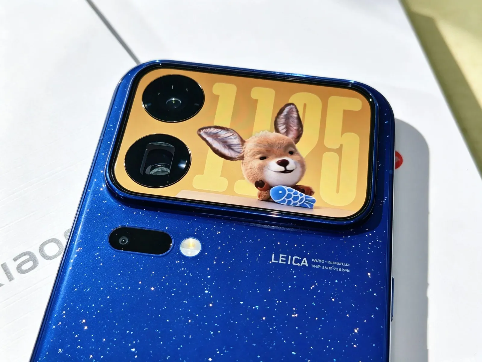 Pantalla trasera del Xiaomi 18 Pro con un fondo animado junto a las cámaras Leica