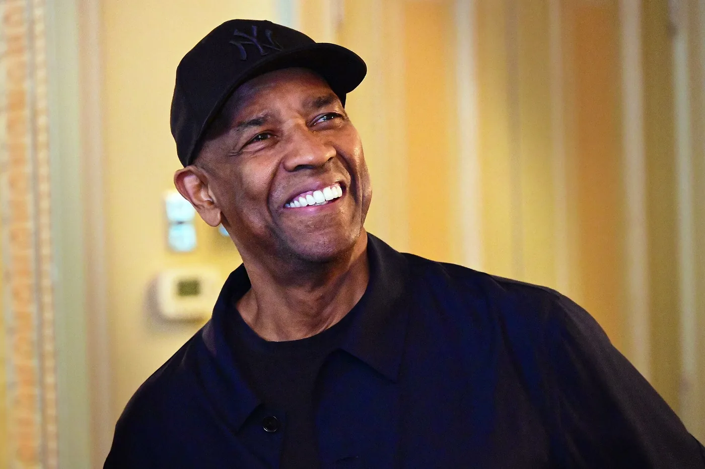 Denzel Washington sonriendo con gorra negra
