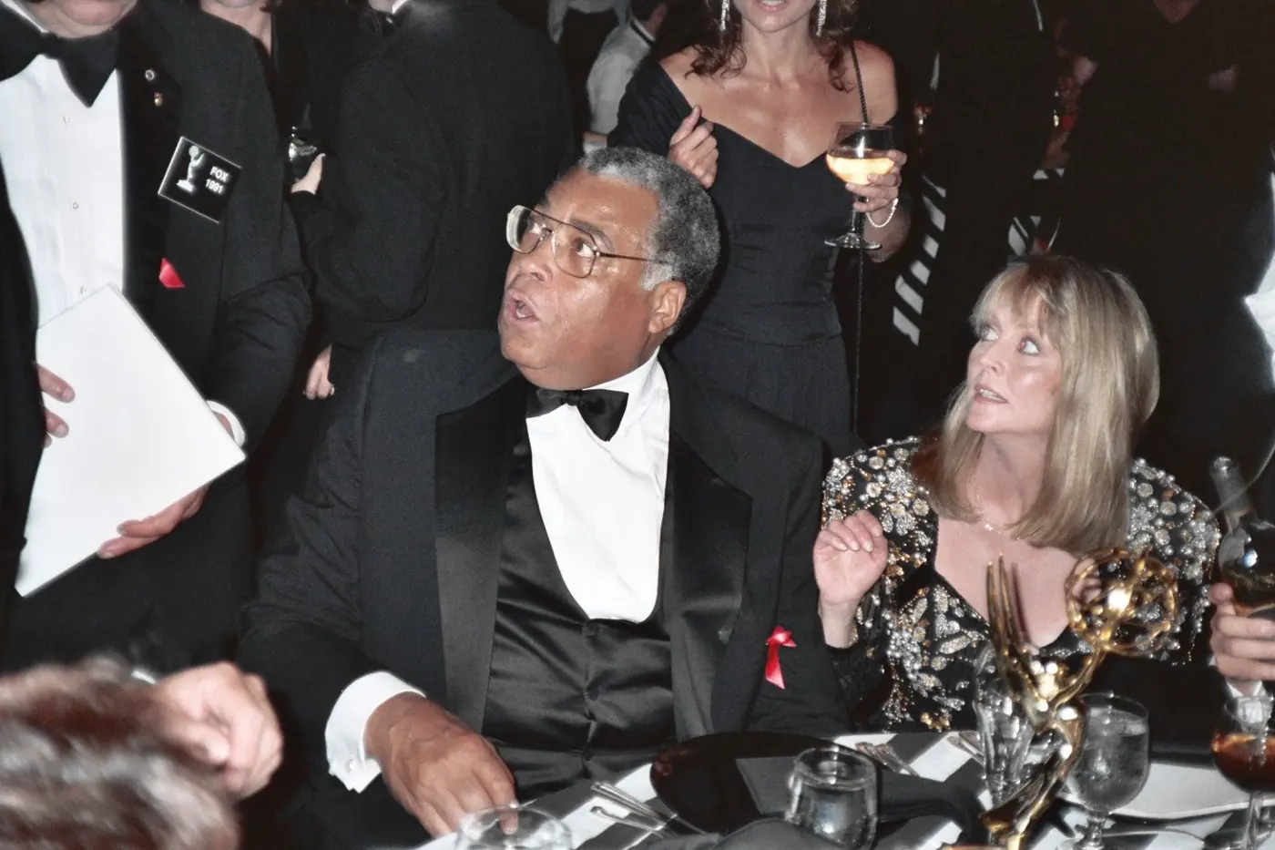 James Earl Jones sentado en la mesa del Governor's Ball de los Emmy 1991, con dos estatuillas sobre el mantel
