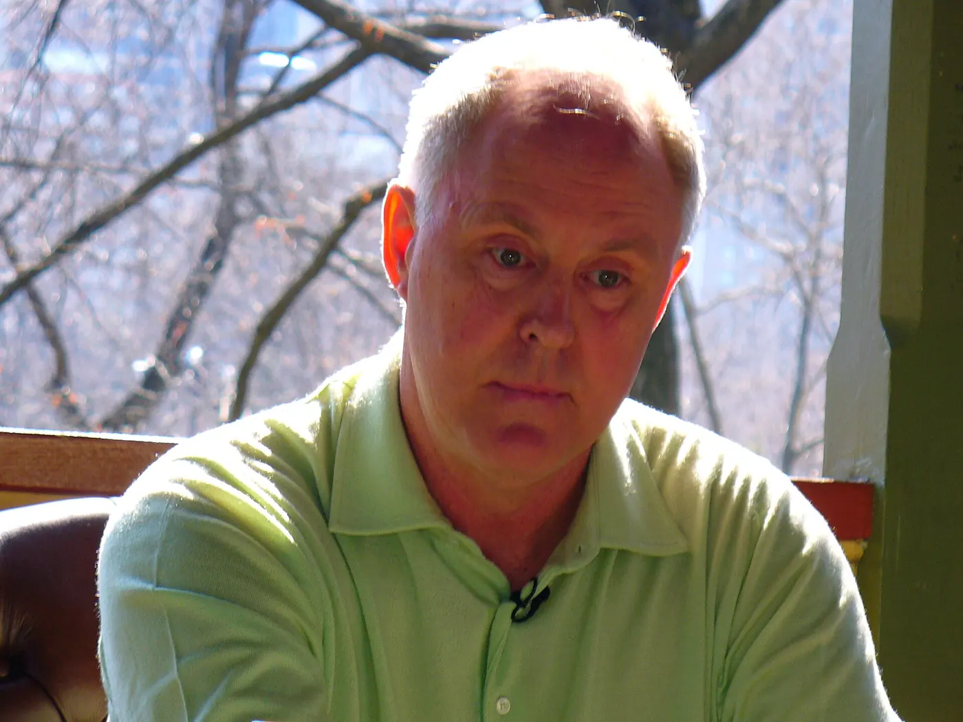 John Lithgow con chomba verde en un evento al aire libre en Central Park