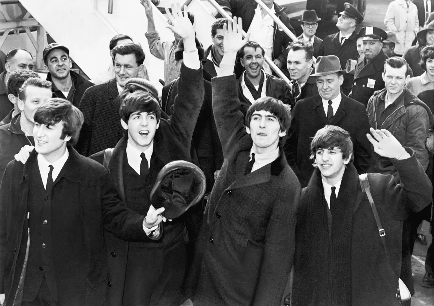 Los Beatles saludan a su llegada al aeropuerto JFK de Nueva York en 1964