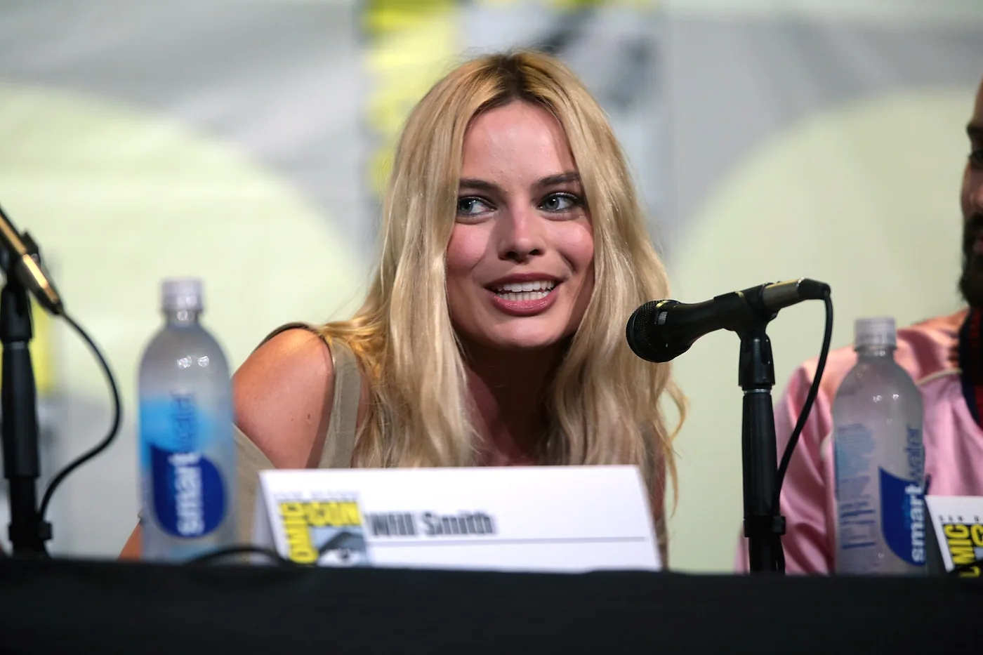Margot Robbie sonriente durante un panel en la San Diego Comic-Con
