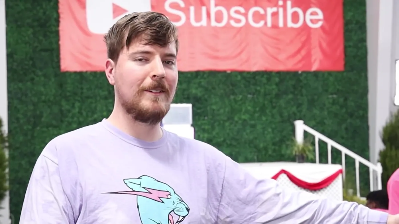 El youtuber MrBeast, Jimmy Donaldson, sonríe frente a un cartel de suscripción de YouTube