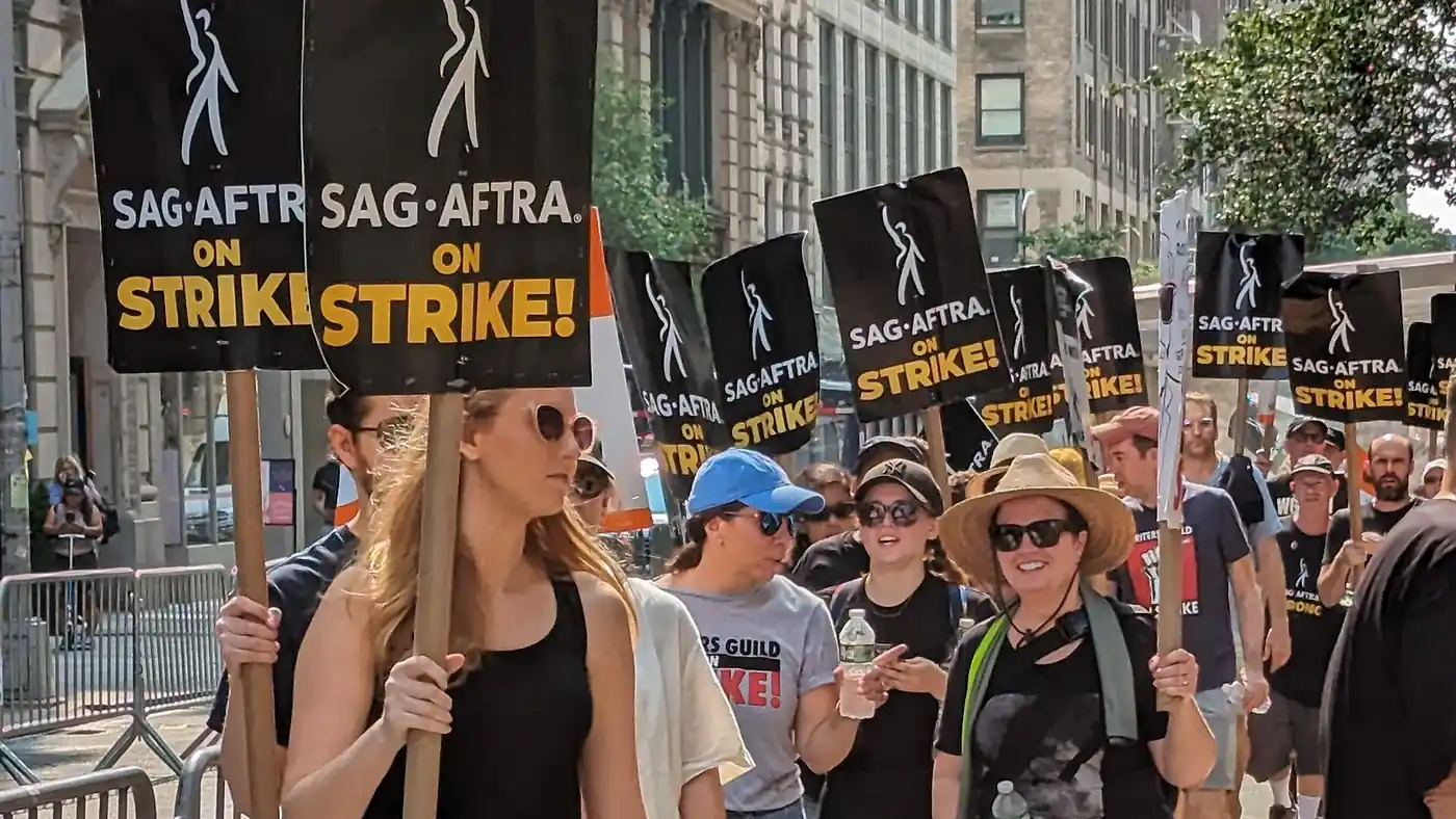 Actores y actrices marchan en un piquete de SAG-AFTRA en Nueva York con carteles de huelga