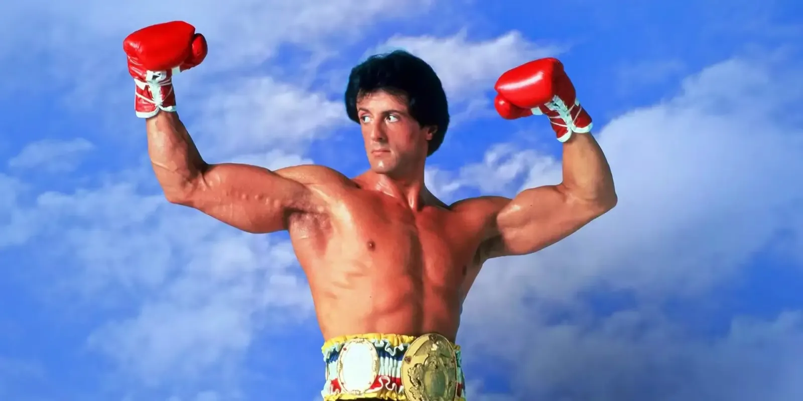 Sylvester Stallone como Rocky Balboa, con los guantes en alto y el cinturón de campeón