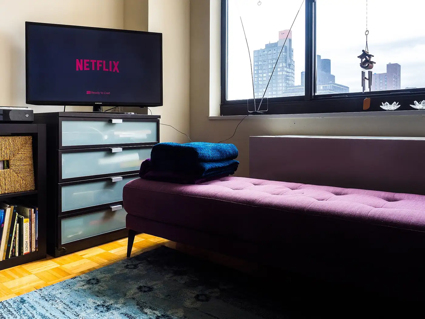 Televisor con la pantalla de inicio de Netflix encendido en el living de un departamento
