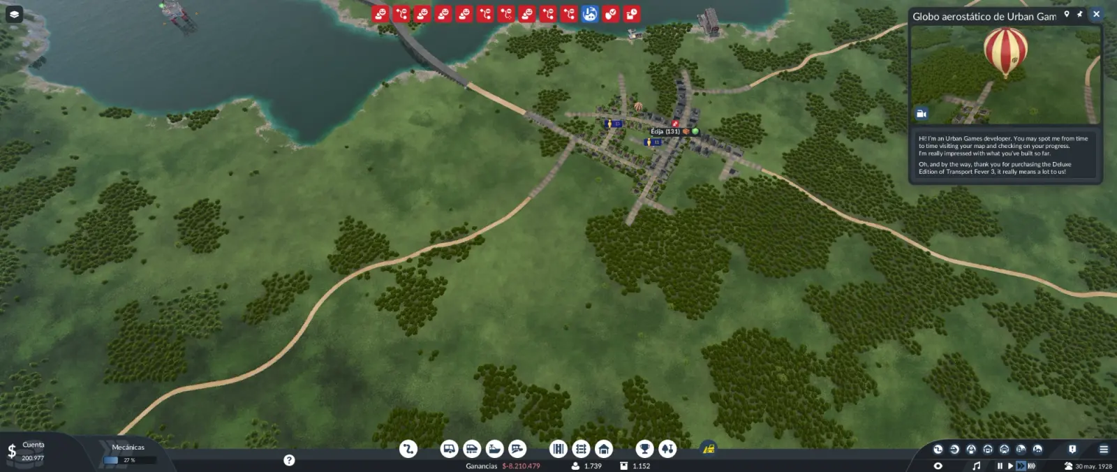 Globo aerostático de Urban Games sobrevolando el pueblo de Écija en Transport Fever 3, con el mensaje del desarrollador en pantalla