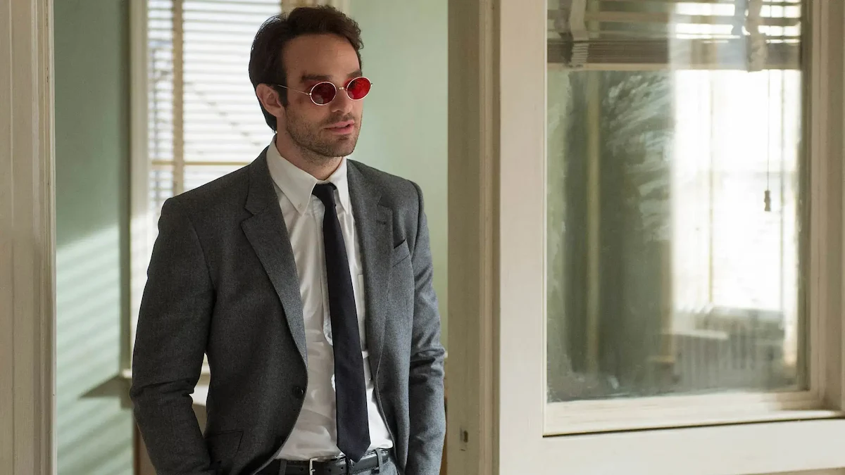 Charlie Cox de traje y anteojos rojos como Matt Murdock en Daredevil