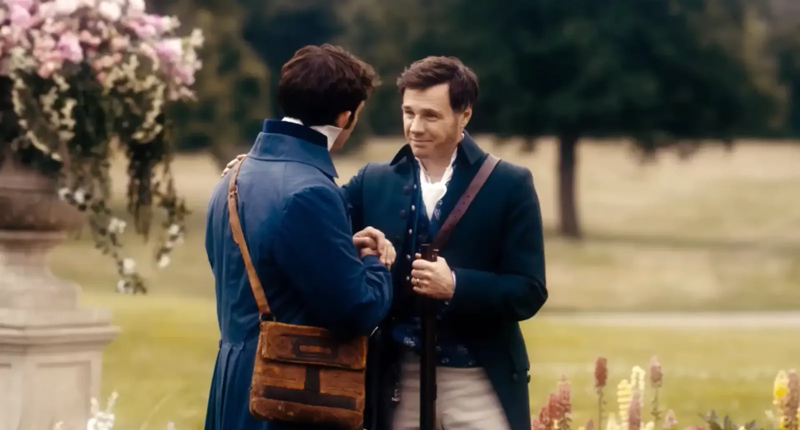 Rupert Evans como Edmund Bridgerton junto a su hijo Anthony en un jardín, en la serie de Netflix