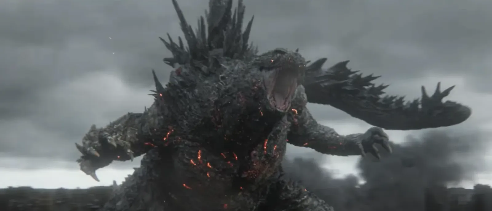 Godzilla, con el cuerpo marcado por destellos rojos, ruge bajo un cielo gris