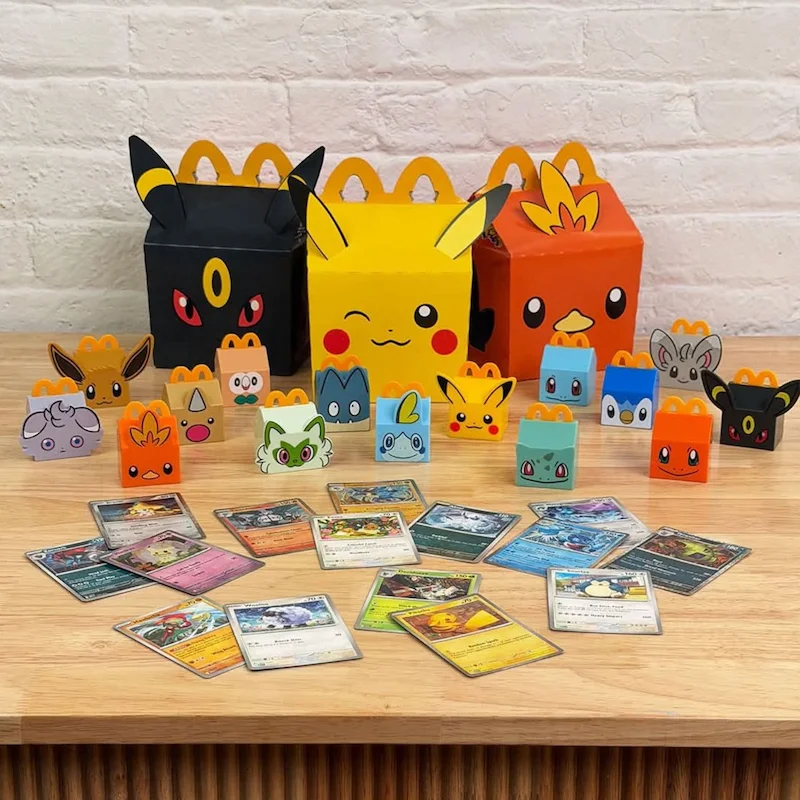 Las tres Cajitas Felices de Pokémon (Umbreon, Pikachu y Torchic), con los 15 juguetes y las cartas del JCC Pokémon