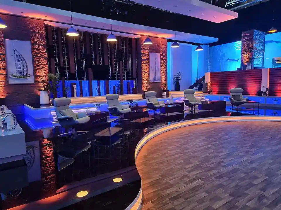Set de una versión internacional de Shark Tank, con los sillones de los tiburones y paneles iluminados