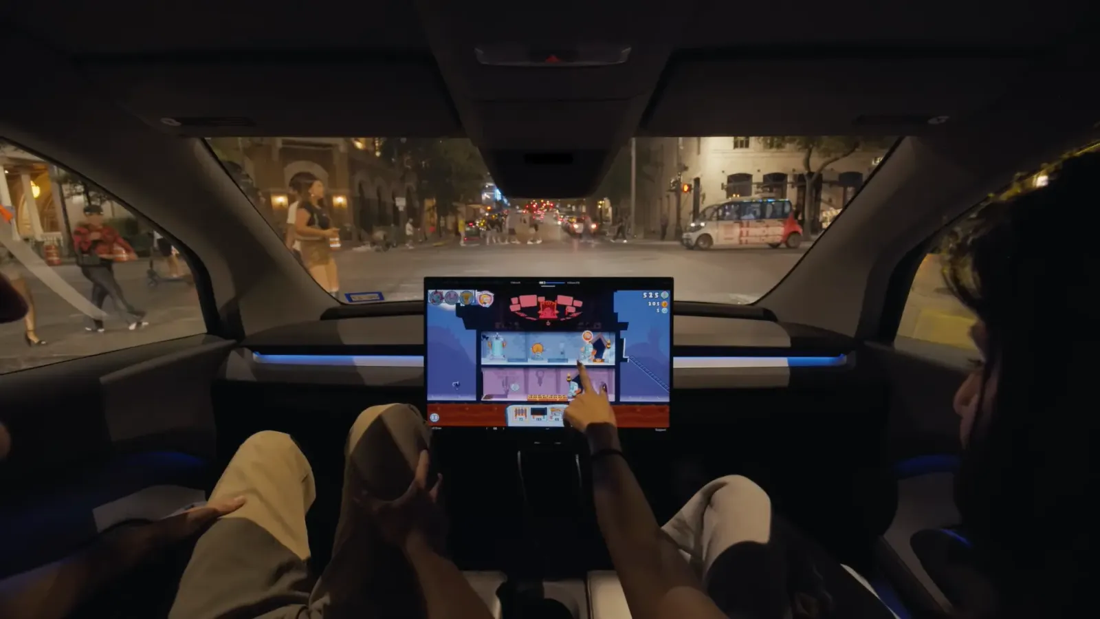 Pasajeros jugando en la pantalla del Cybercab, el vehículo autónomo de Tesla que se utiliza como robotaxi