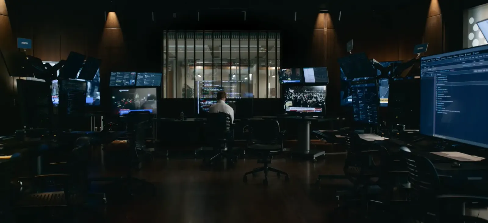 Oficina a oscuras llena de monitores encendidos en una escena de The Social Reckoning