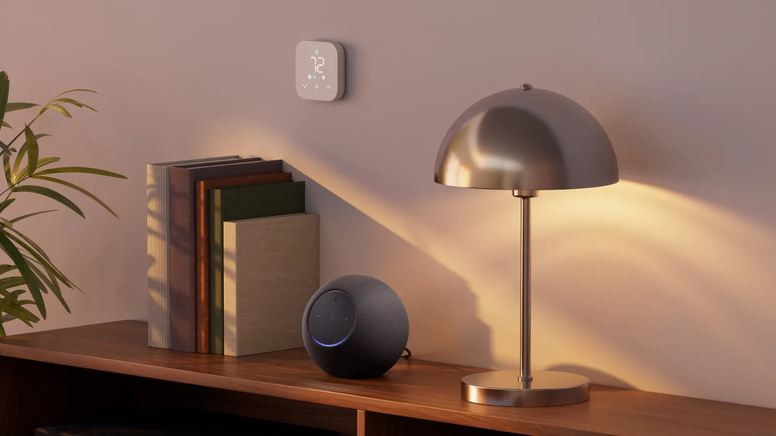 Nuevo Amazon Echo Studio color grafito sobre un mueble junto a una lámpara