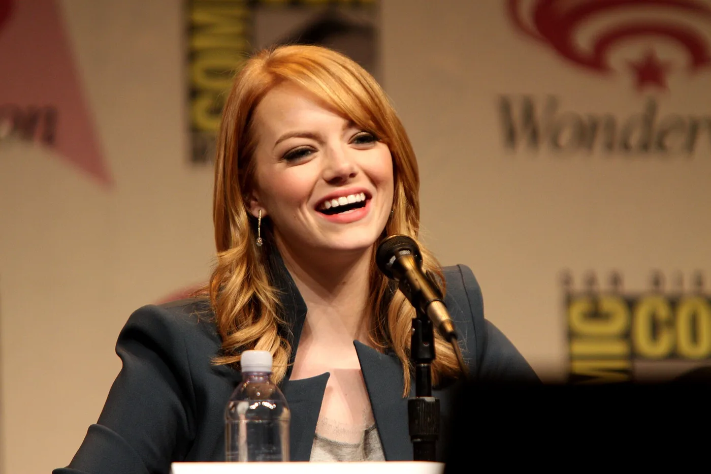Emma Stone, la protagonista de Cruella, sonriendo frente al micrófono en un panel de la WonderCon 2012
