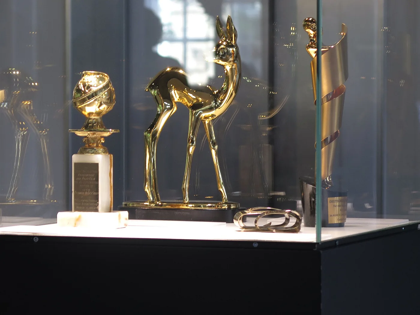 Estatuilla de los Golden Globe exhibida junto a un premio Bambi en una vitrina del Museo Alemán del Cine