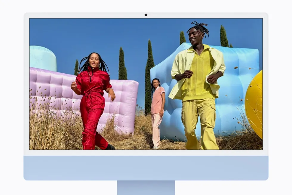 iMac con M6 azul con una foto de tres personas en un campo en pantalla