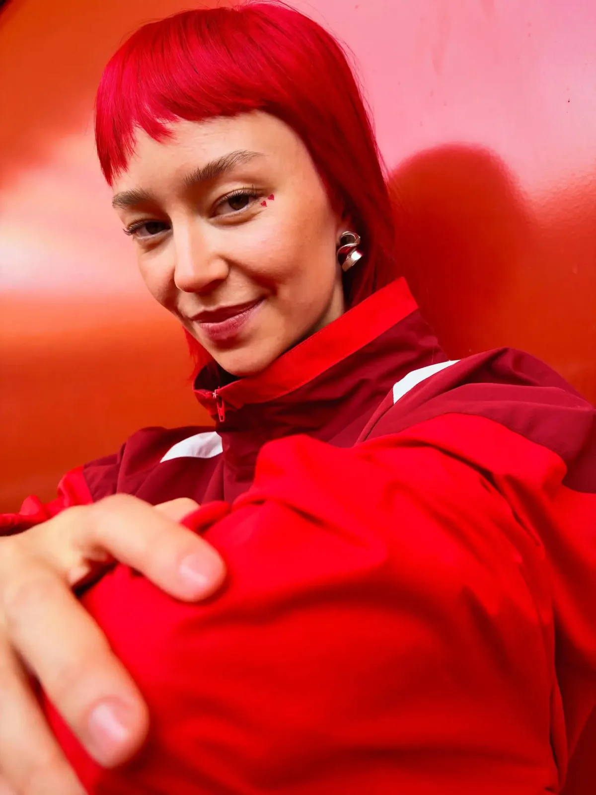 Foto de muestra del iPhone Duo: retrato de una mujer de pelo rojo con campera roja