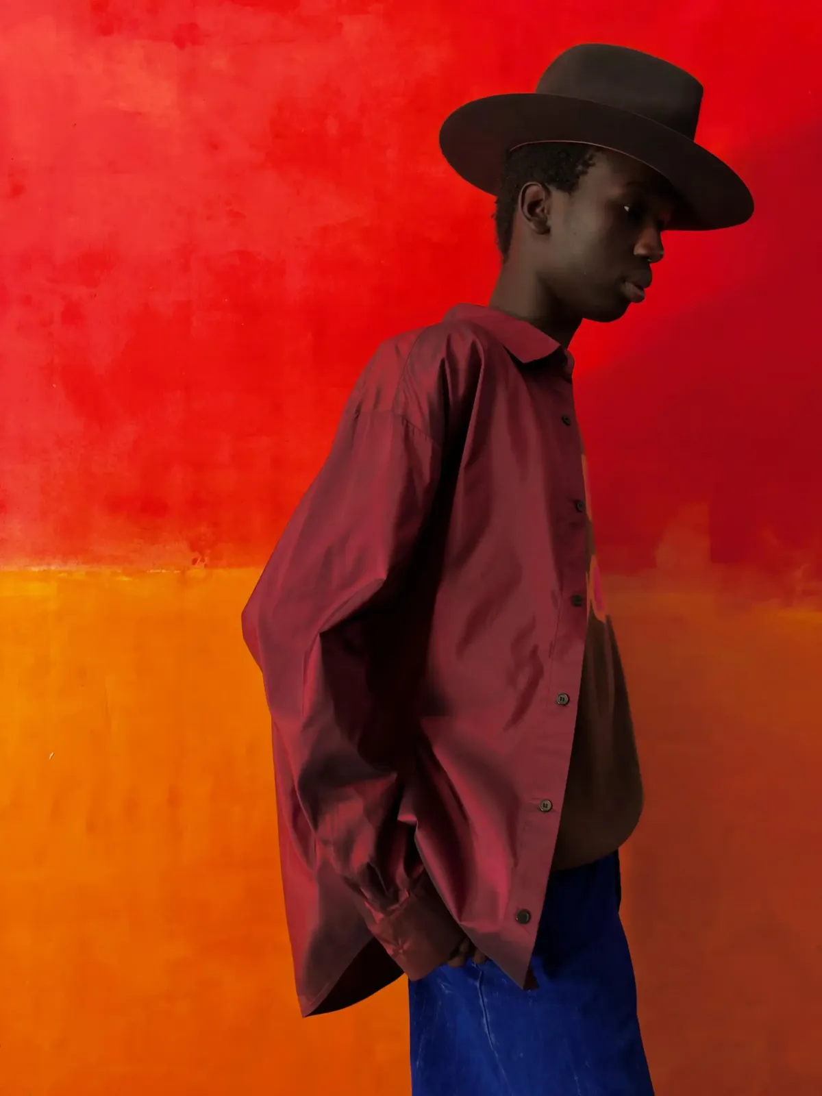 Foto de muestra del iPhone Duo: un hombre con sombrero frente a una pared roja y naranja
