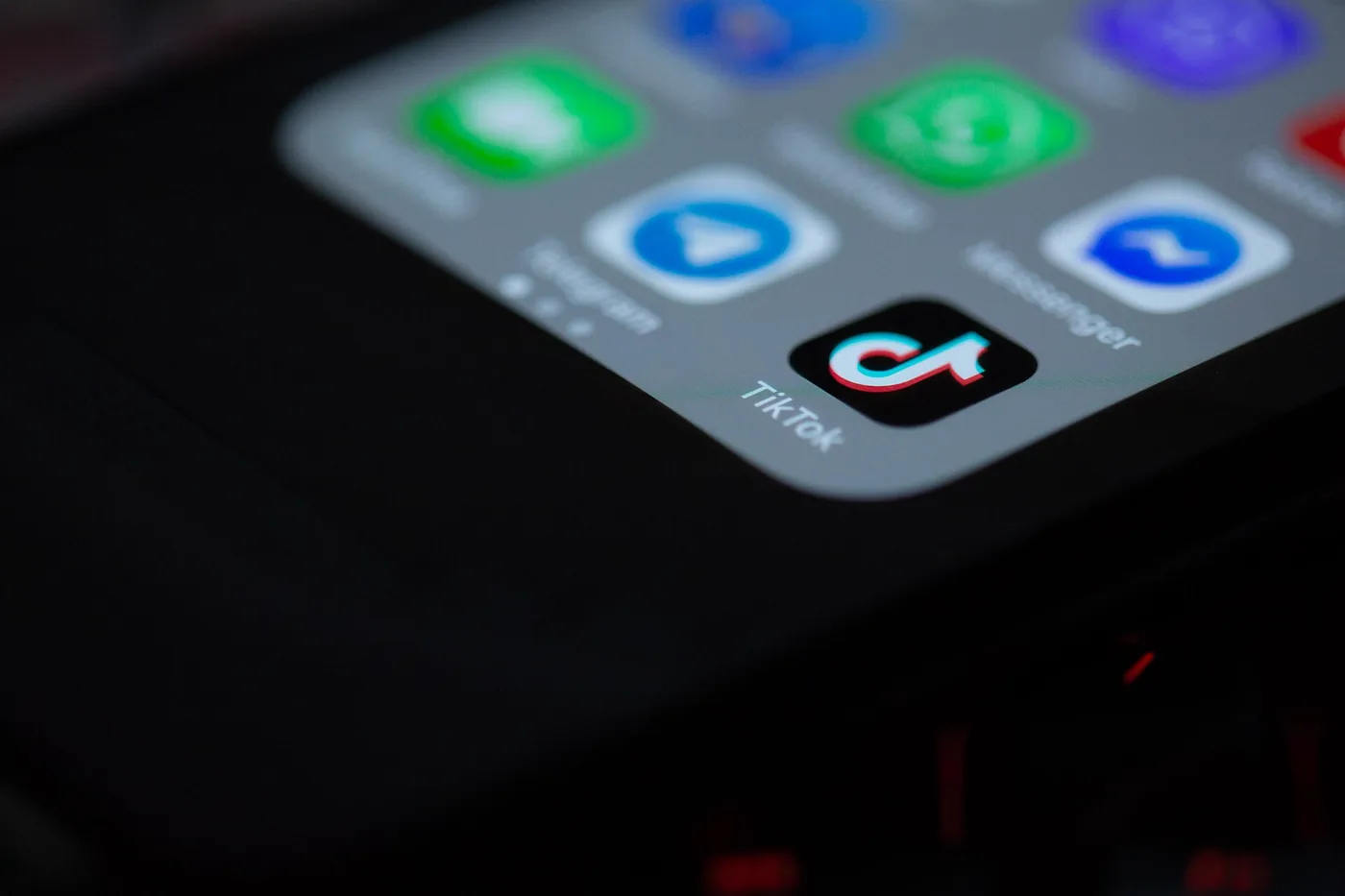 Pantalla de un celular con el ícono de la app de TikTok entre otras aplicaciones