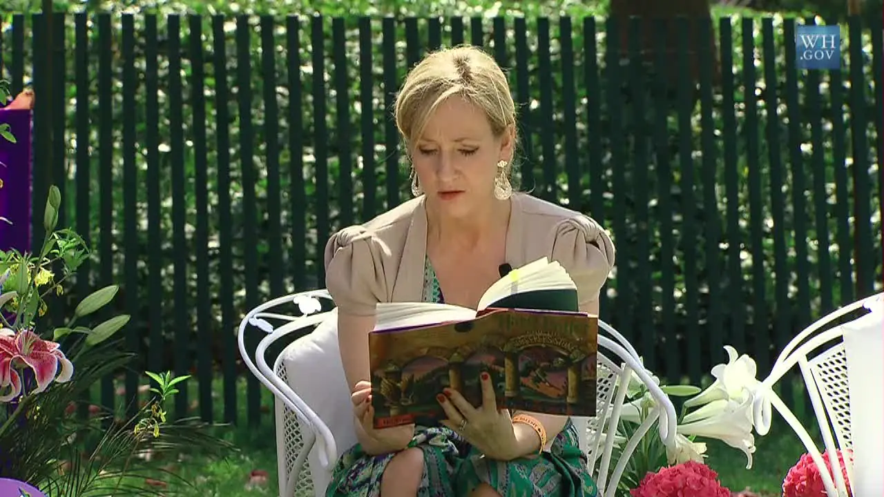 J.K. Rowling lee Harry Potter y la piedra filosofal sentada en un jardín de la Casa Blanca, en 2010