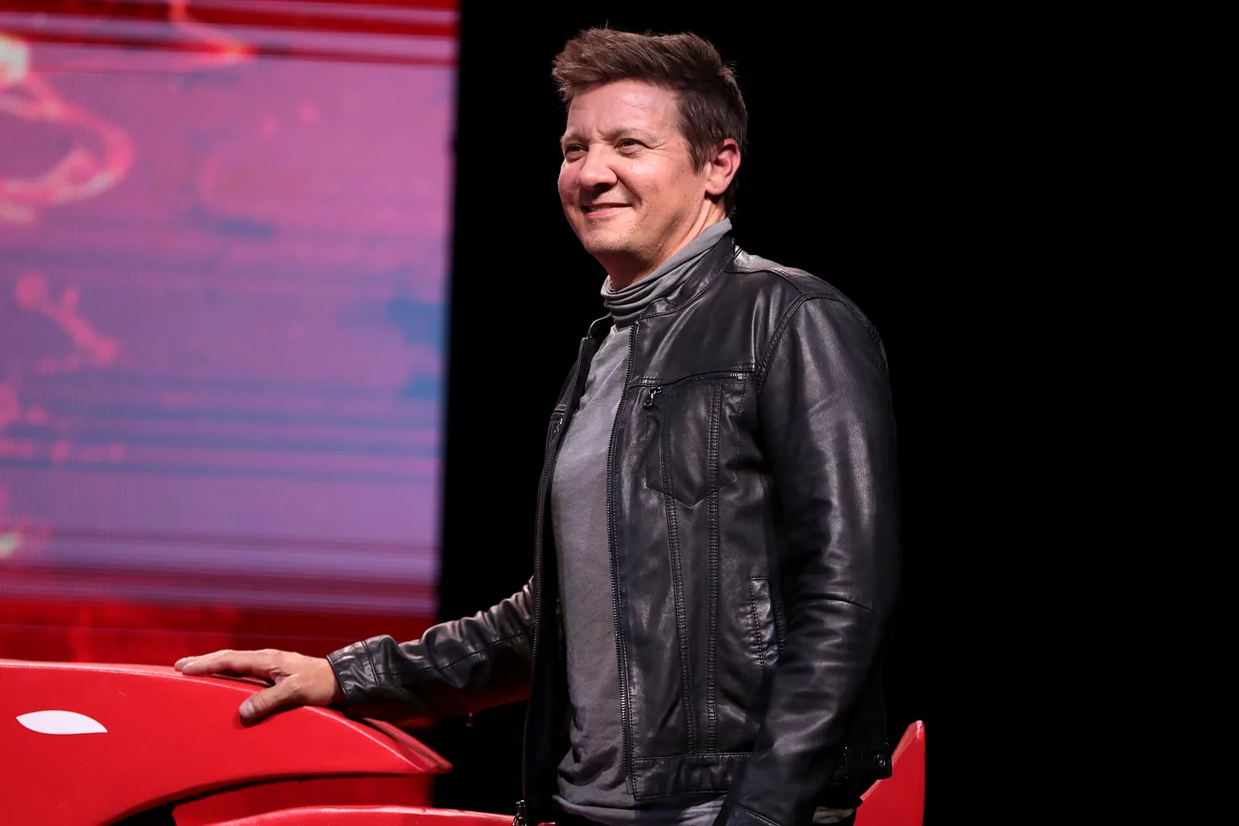 Jeremy Renner sonríe en el escenario de la convención Phoenix Fan Fusion