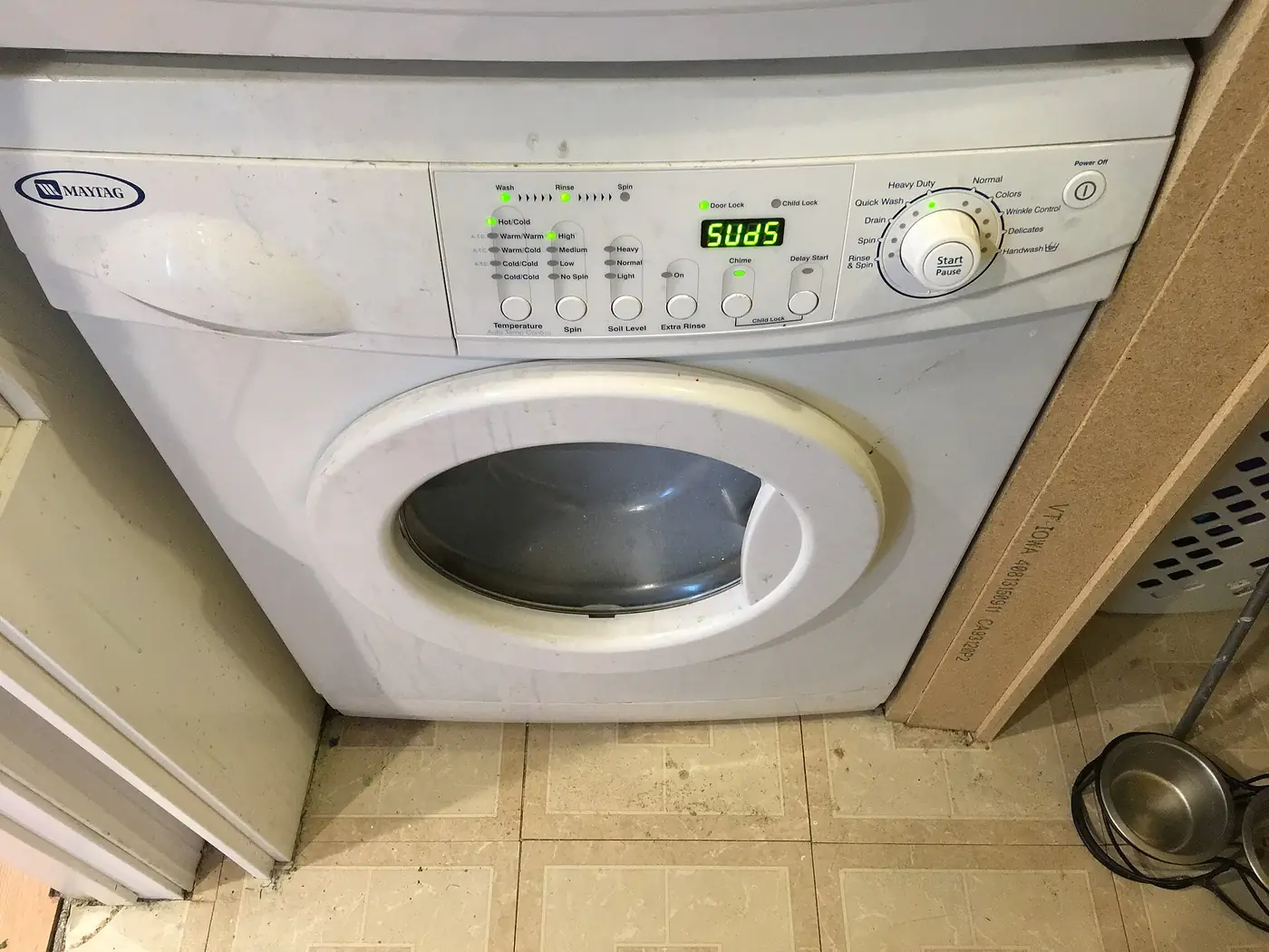 Lavarropas de carga frontal Maytag con un aviso de exceso de espuma en el panel