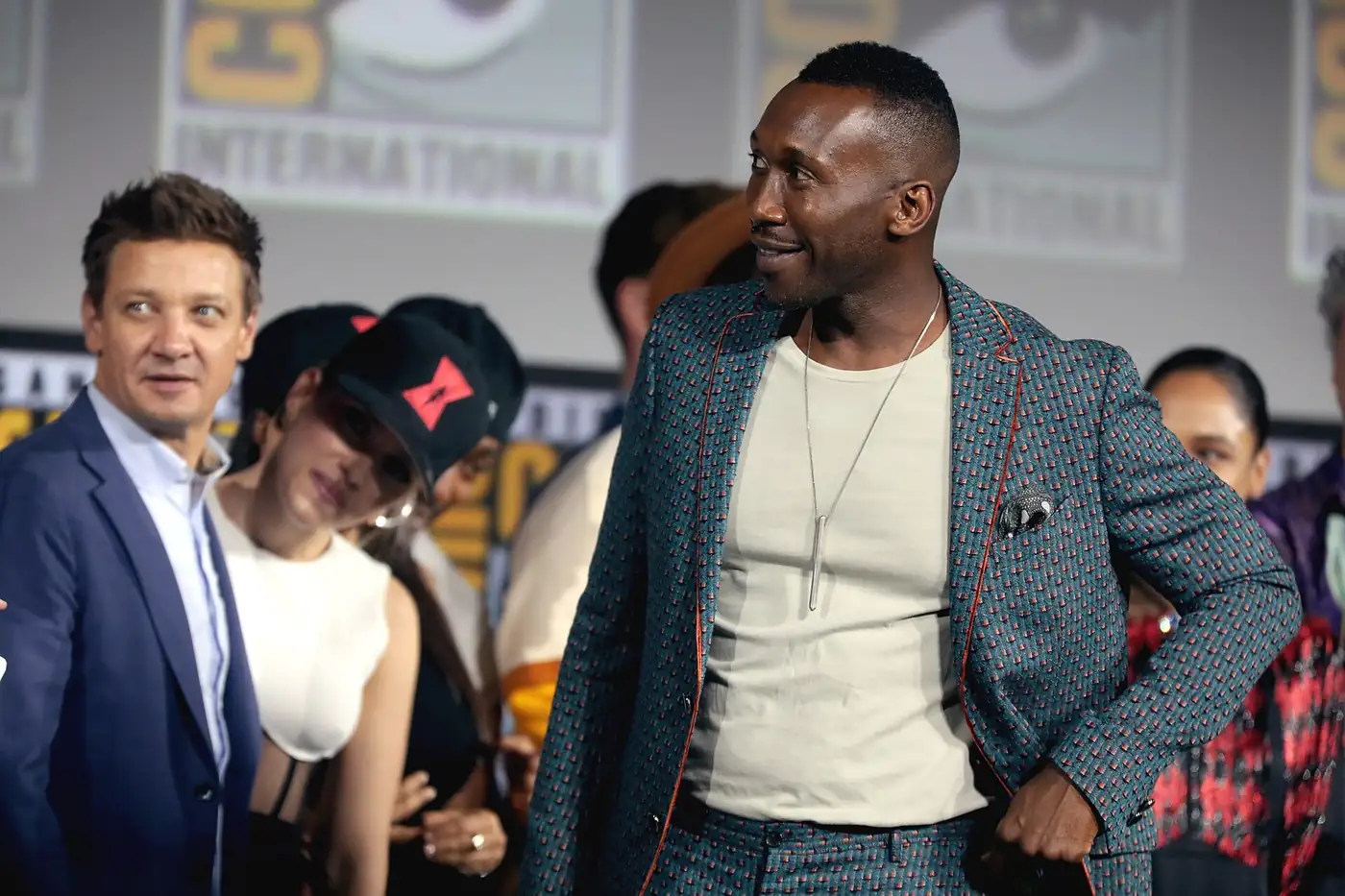 Mahershala Ali sonríe en el escenario del panel de Marvel Studios en la Comic-Con de San Diego, junto a Jeremy Renner