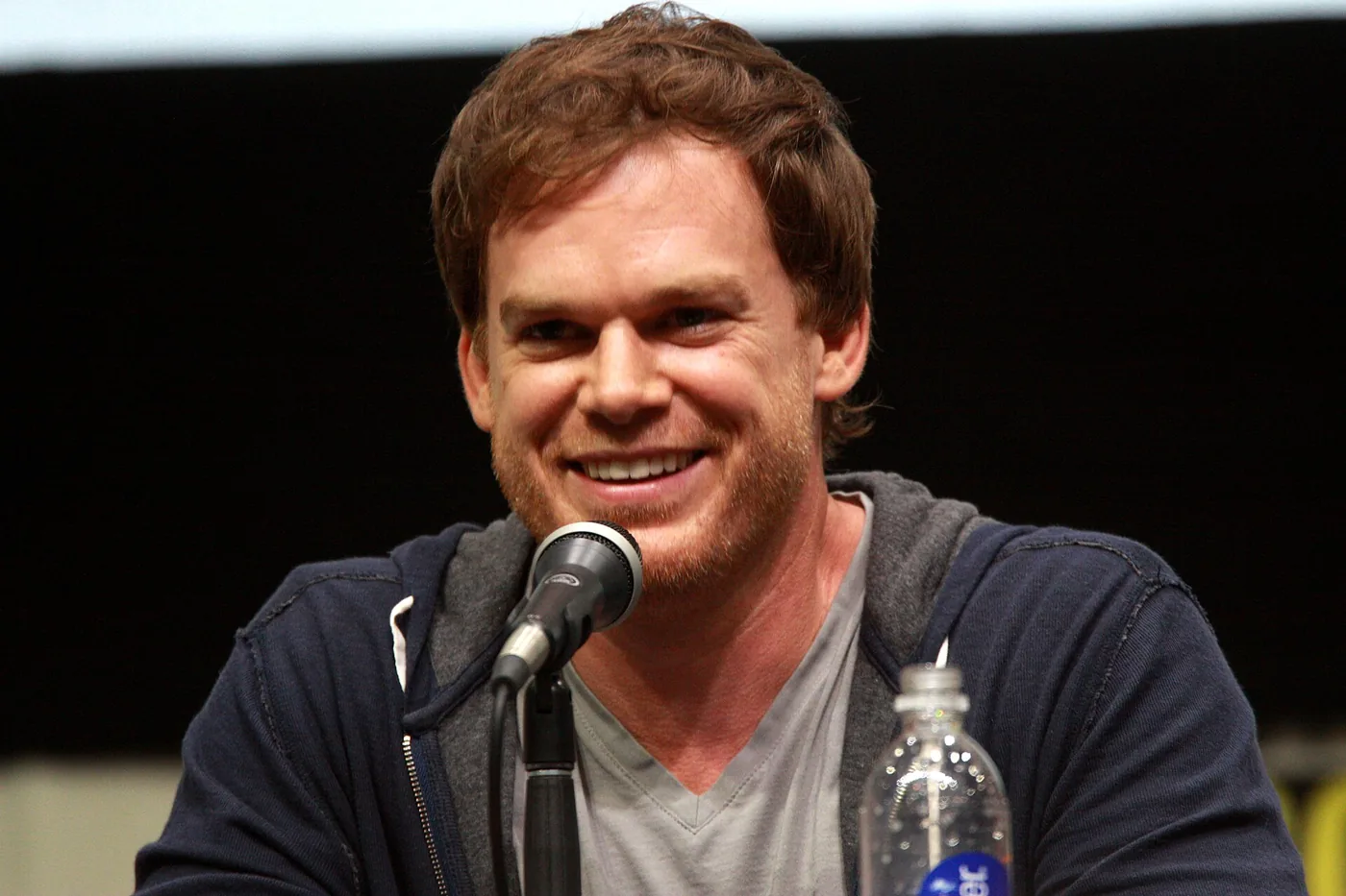 Michael C. Hall sonríe frente al micrófono en el panel de Dexter de la Comic-Con de San Diego 2013