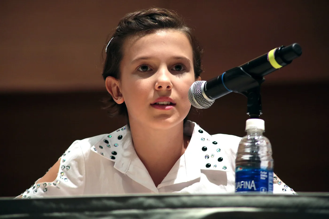 Millie Bobby Brown habla frente al micrófono en un panel de la San Diego Comic-Con de 2016