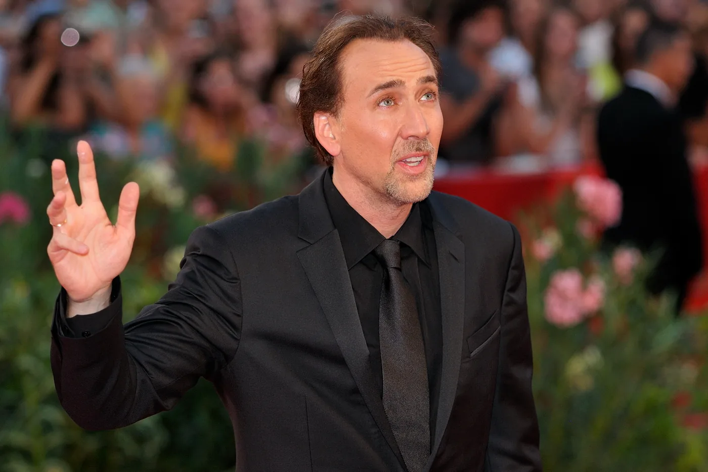 Nicolas Cage saluda con la mano en la alfombra roja del Festival de Venecia