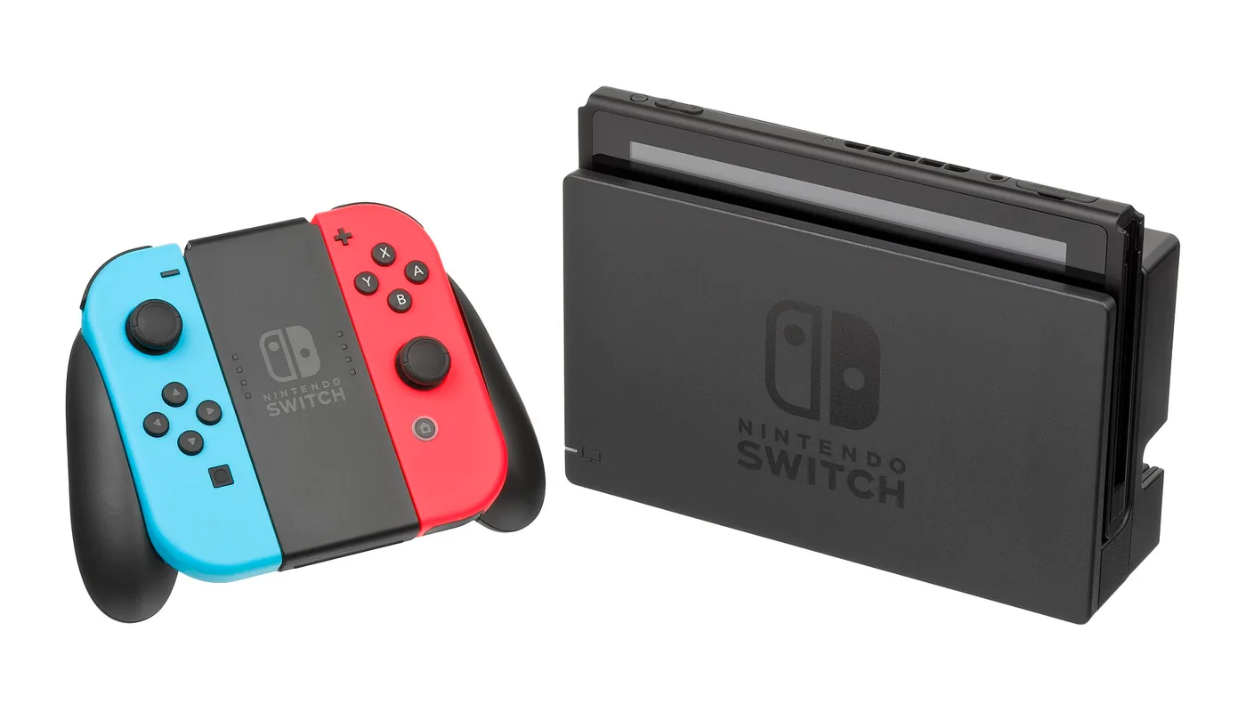 Consola Nintendo Switch en su dock junto a los Joy-Con armados en el soporte Joy-Con Grip