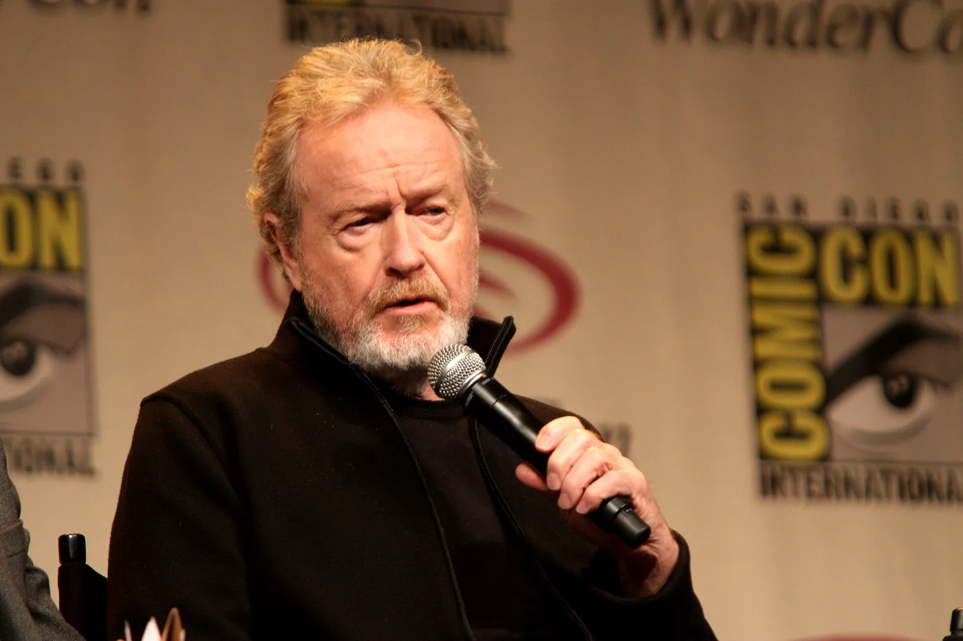 Ridley Scott habla con un micrófono en la mano durante un panel de la WonderCon