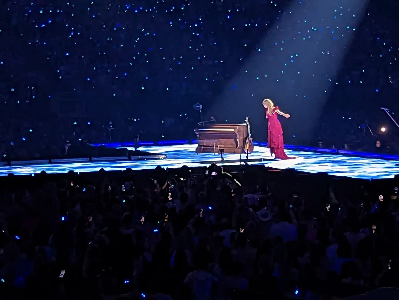 Taylor Swift en el escenario iluminado durante el set acústico del Eras Tour en Minneapolis